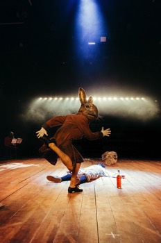  Br'er Rabbit (Cassie Clare) is tap dancing over the dead body of a young black boy Paul (Alistair Toovey), the actor playing Paul donned black paint over his face in the beginning scene to play the black male characters. The actor playing Br'er Rabbit wears a full size photo realistic rabbit head. A long line of lights are chasing behind her. 